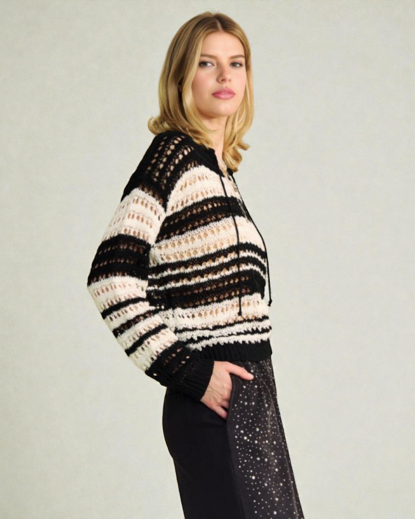 Woman wearing a black and white striped sweater against a plain background