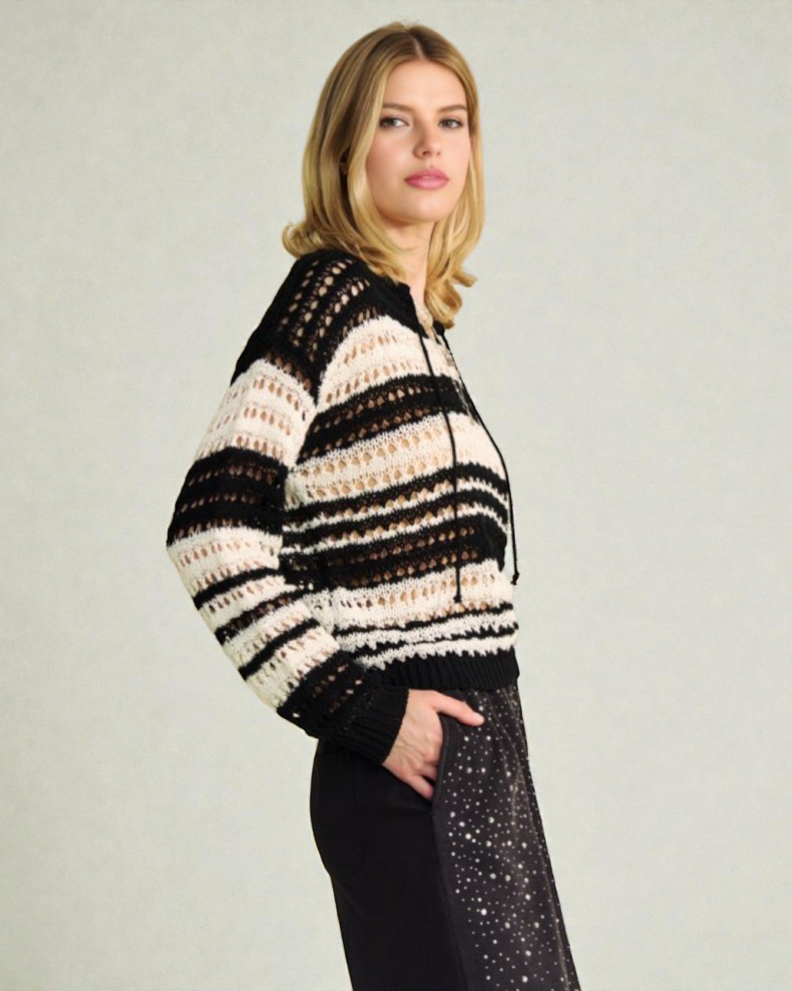 Woman wearing a black and white striped sweater against a plain background