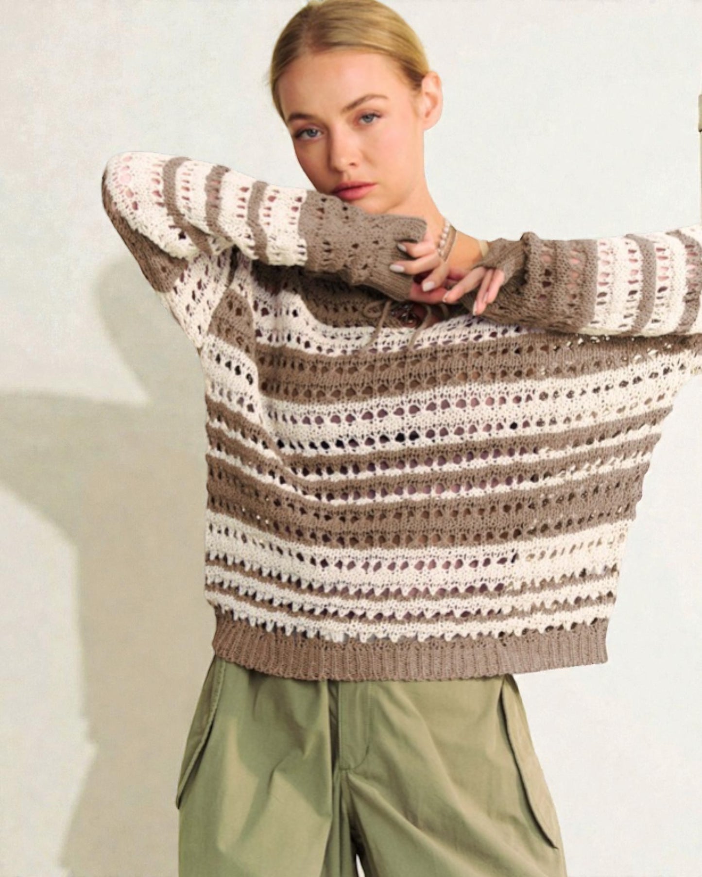 Woman wearing a striped sweater with a plain background