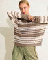 Woman wearing a striped sweater with a plain background