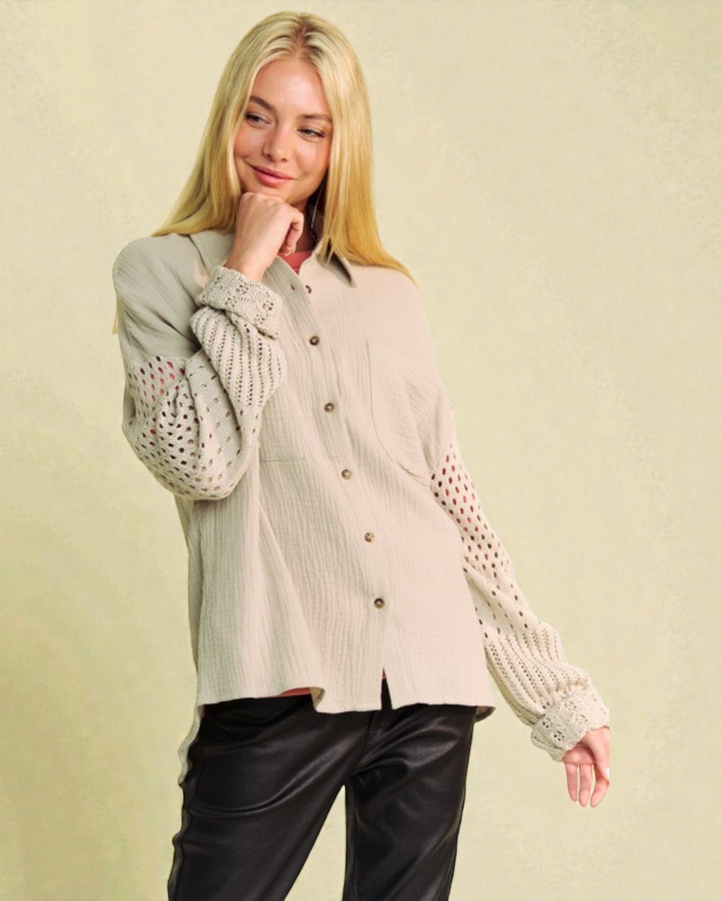 Woman wearing a beige button-up shirt with a patterned sweater over it on a beige background