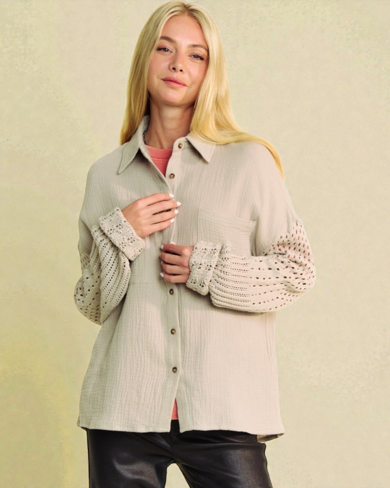Woman wearing a light-colored shirt with lace sleeves against a beige background