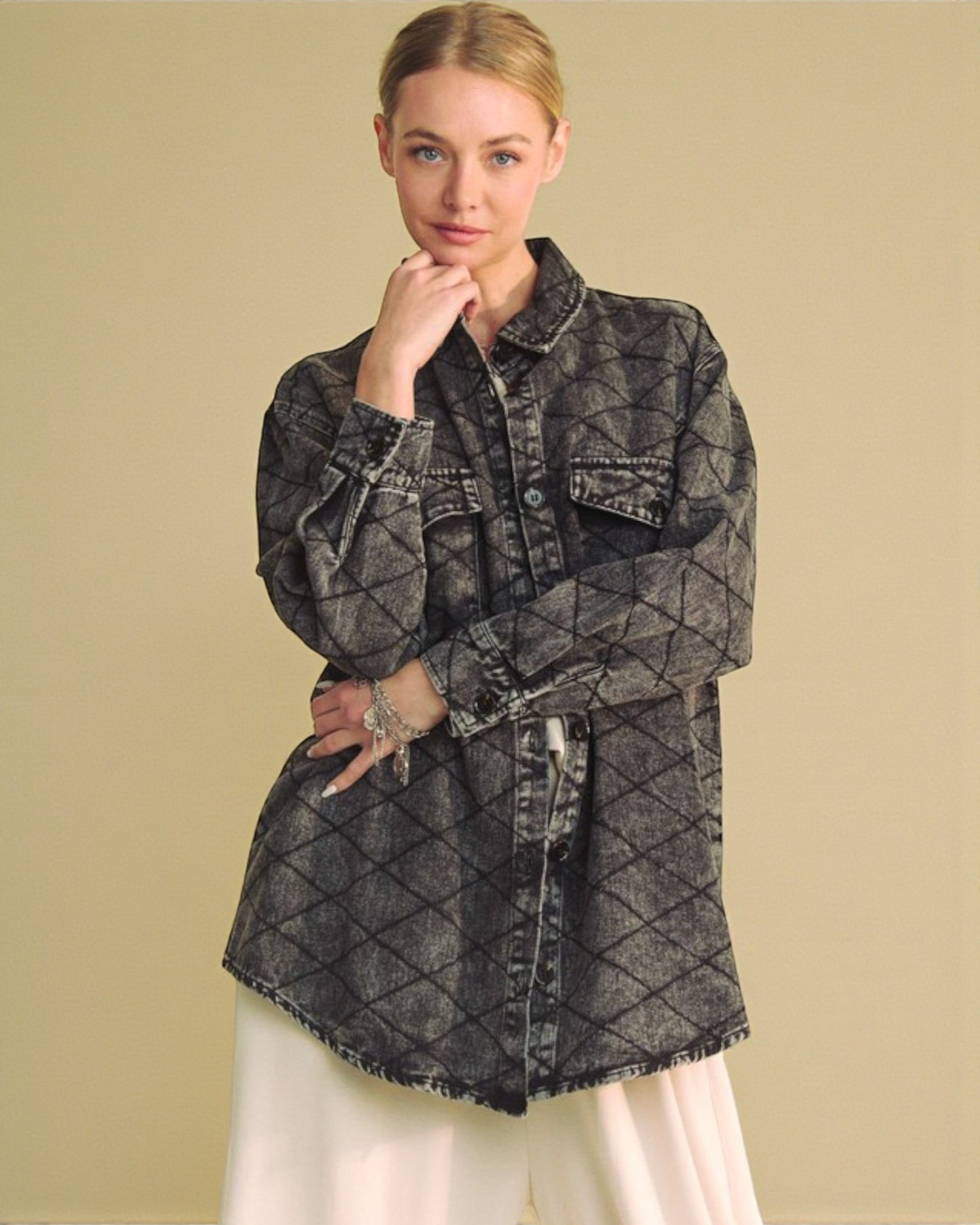 Woman wearing a quilted denim jacket on a beige background
