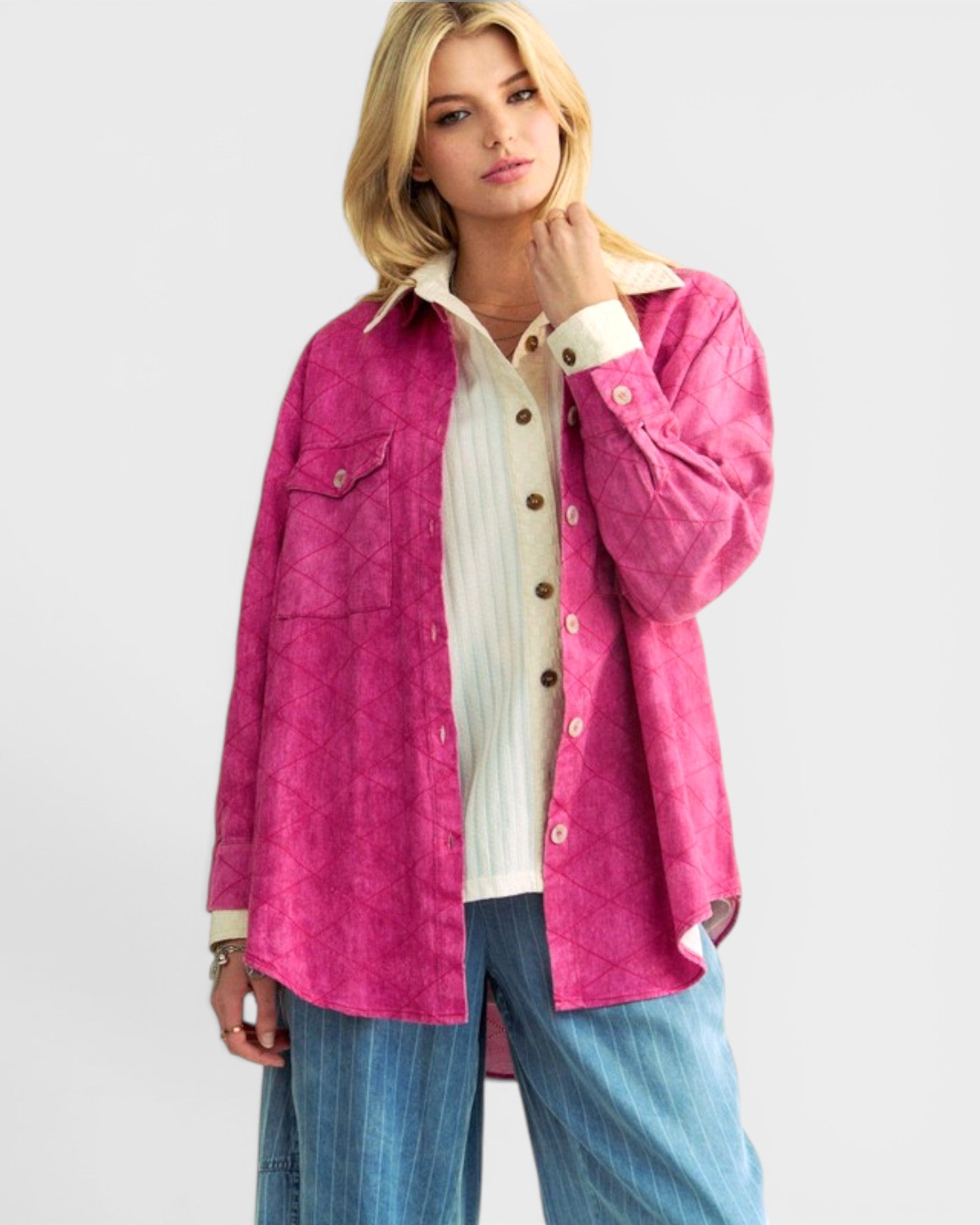 Woman wearing a pink jacket over a white shirt with a plain background