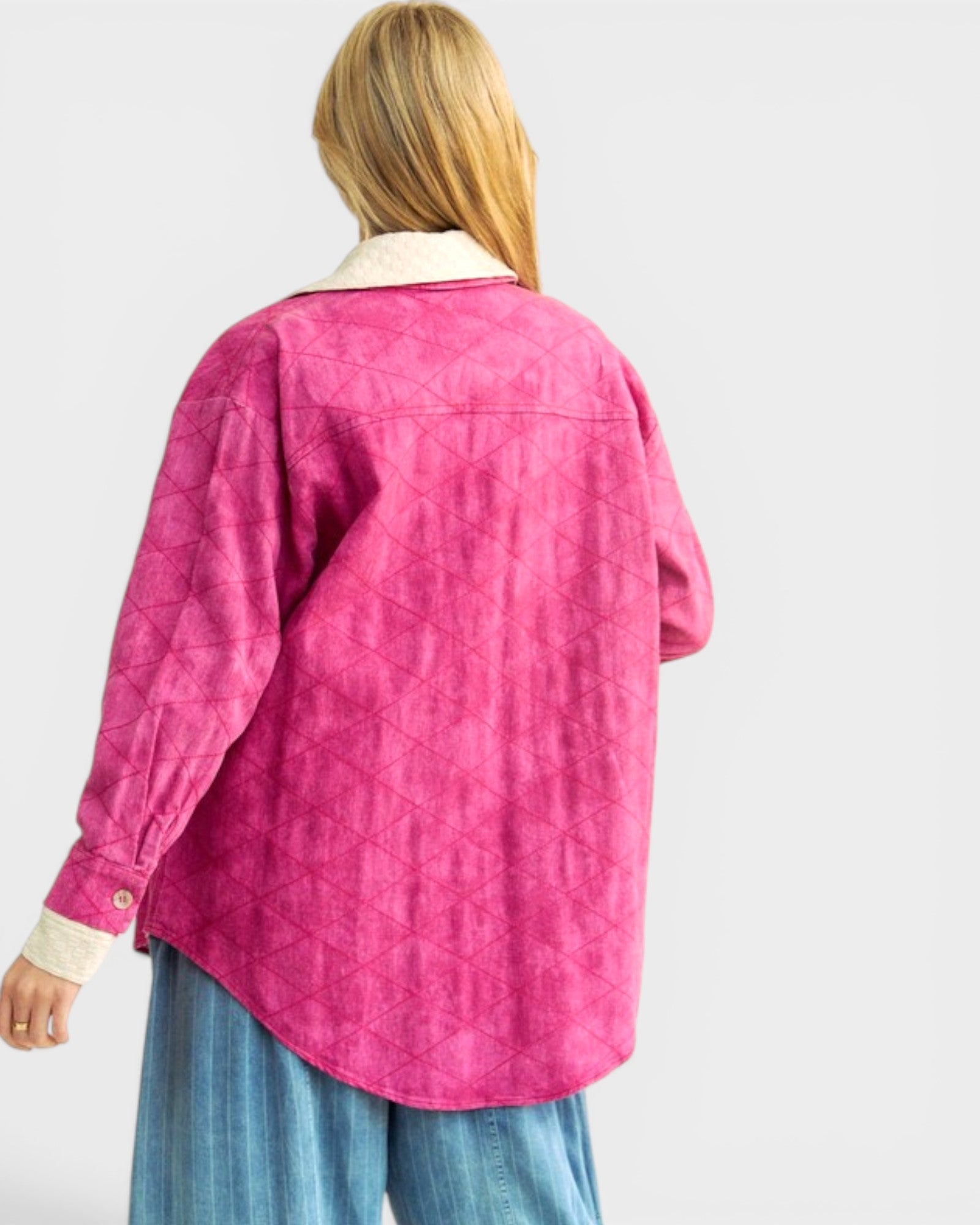 Person wearing a pink quilted jacket on a white background