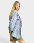 Woman wearing a denim jacket over a green dress on a white background