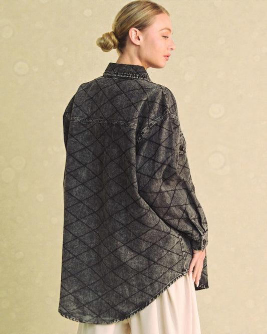 Woman wearing a quilted denim jacket on a beige background