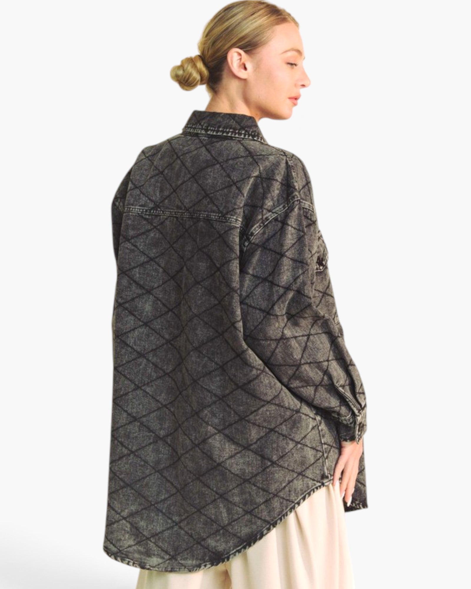 A woman shown from the back wearing a dark charcoal gray quilted button-up shirt with a diamond pattern, paired with a cream skirt, against a plain white background.