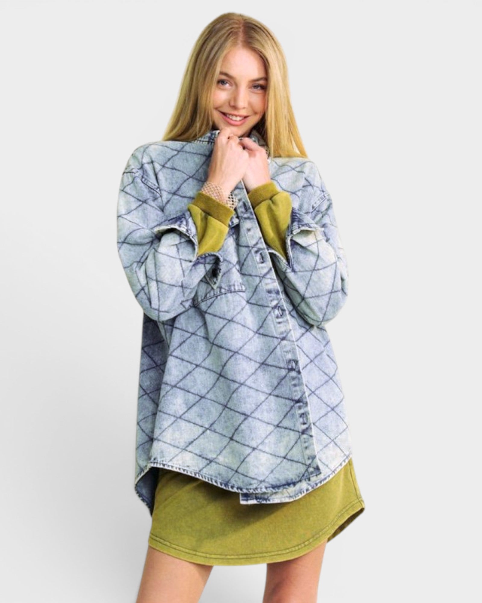 Woman wearing a blue plaid shirt over a green dress on a white background
