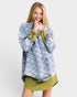 Woman wearing a blue plaid shirt over a green dress on a white background