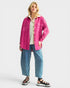 Woman wearing a pink jacket, white shirt, and blue jeans on a white background
