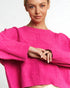 Person wearing a bright pink sweater on a white background