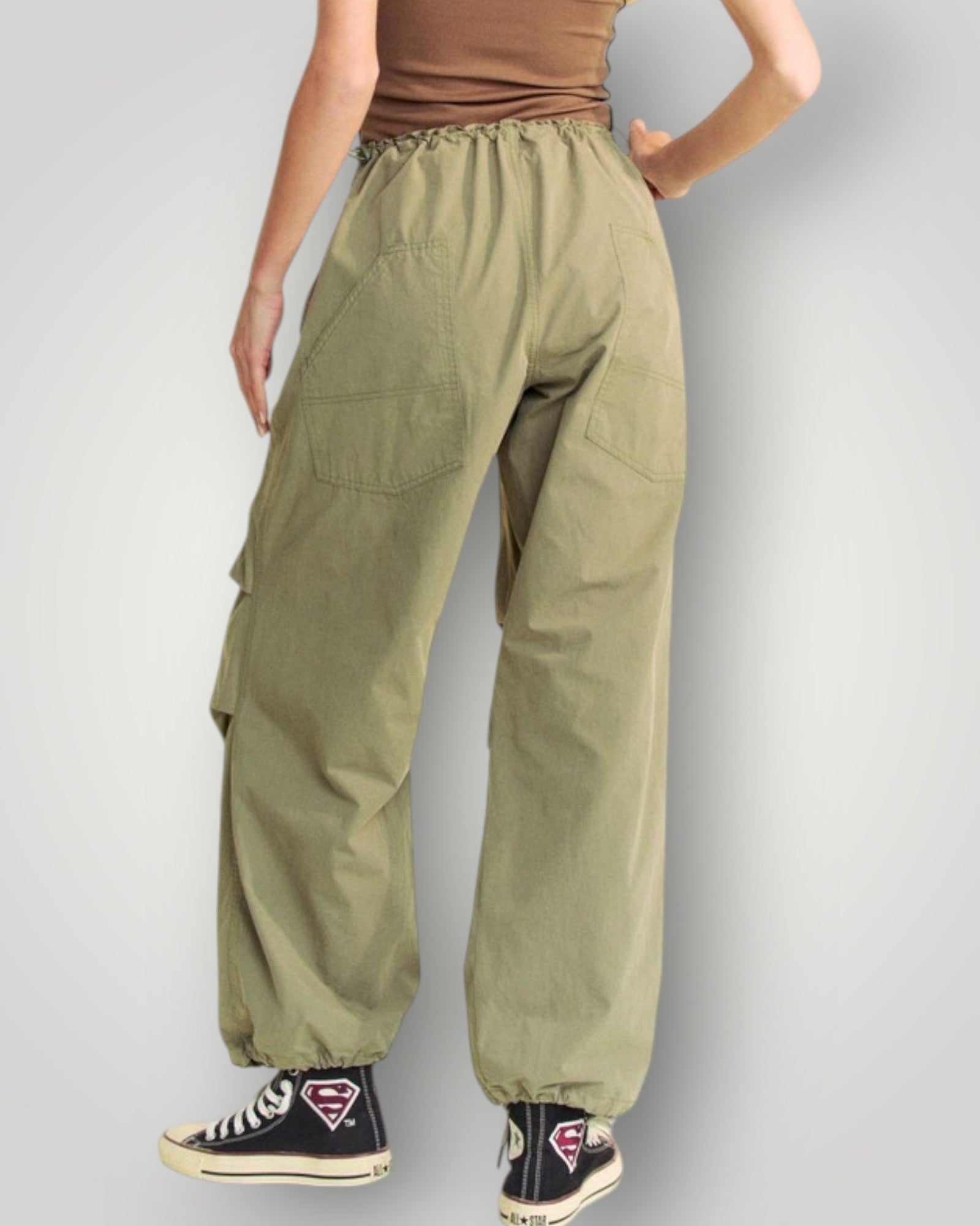 Person wearing olive green cargo pants on a plain background