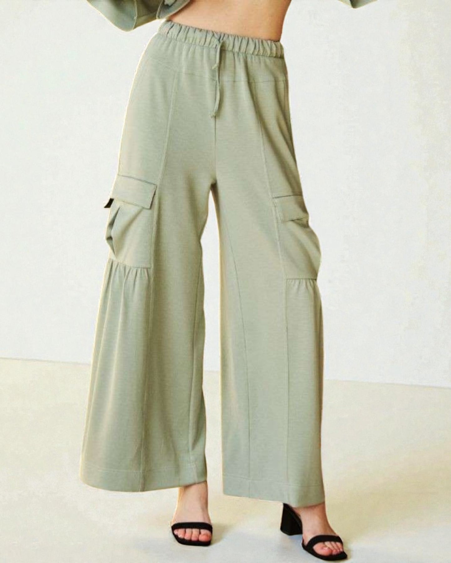 Light green wide-leg pants worn by a person on a white background
