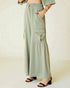 Person wearing light green wide-leg pants with a plain background