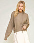 Woman wearing a brown hoodie against a plain background