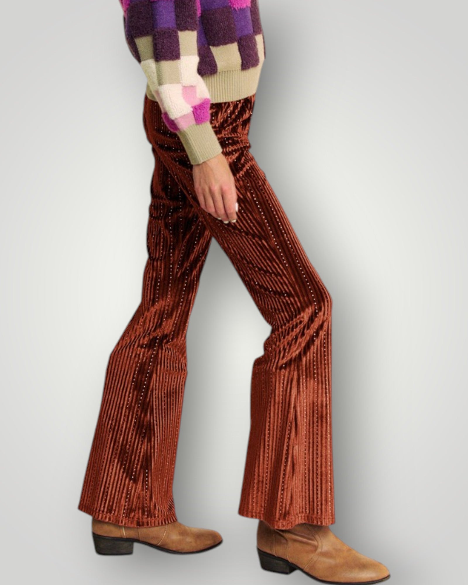 Person wearing brown corduroy bell-bottom pants with a patterned sweater on a light gray background