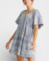 Woman wearing a blue and white patterned dress on a white background