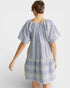 Woman wearing a blue and white patterned dress on a white background