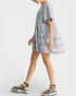 Woman wearing a patterned dress and sandals on a white background