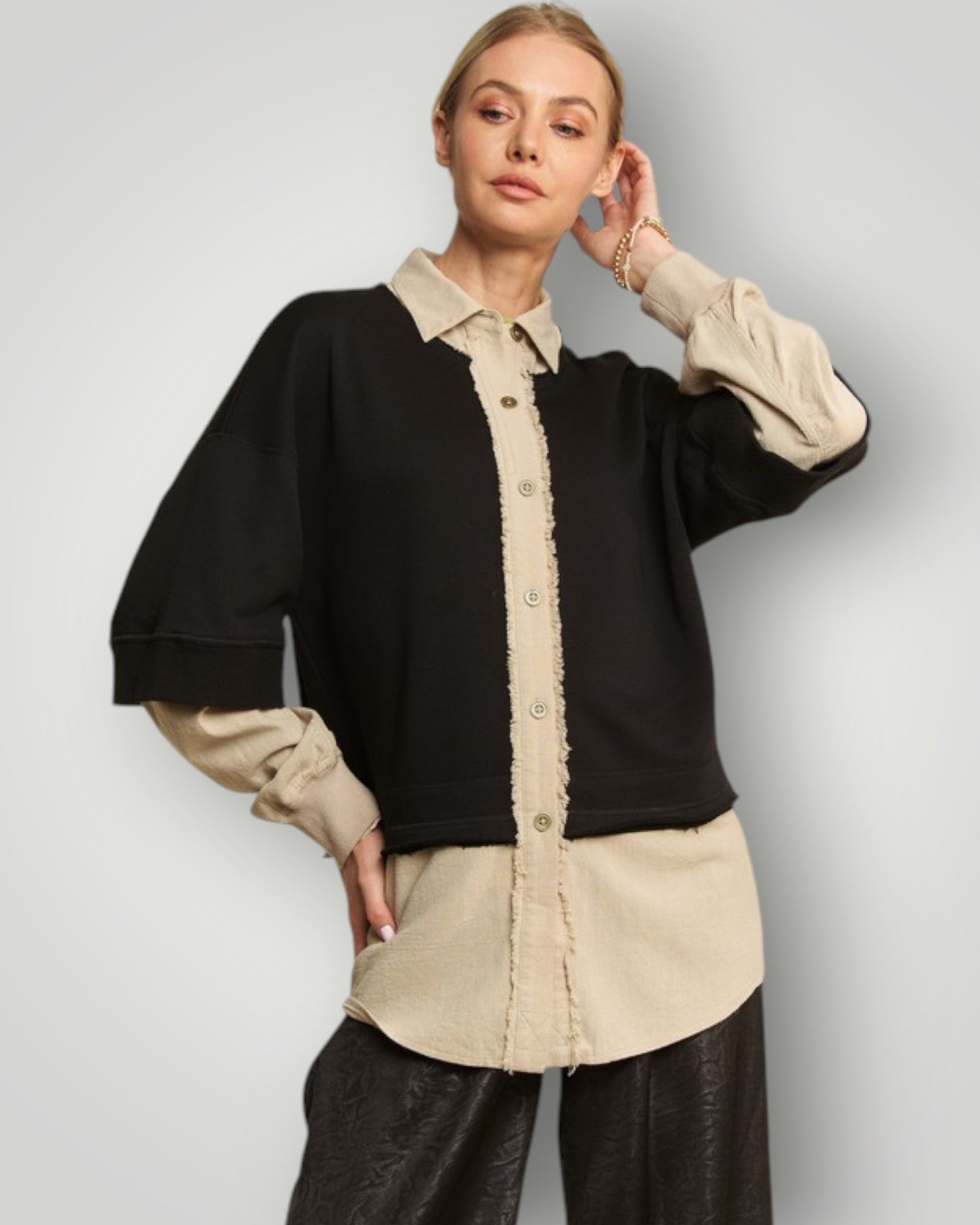 Woman wearing a black and beige outfit with a plain background