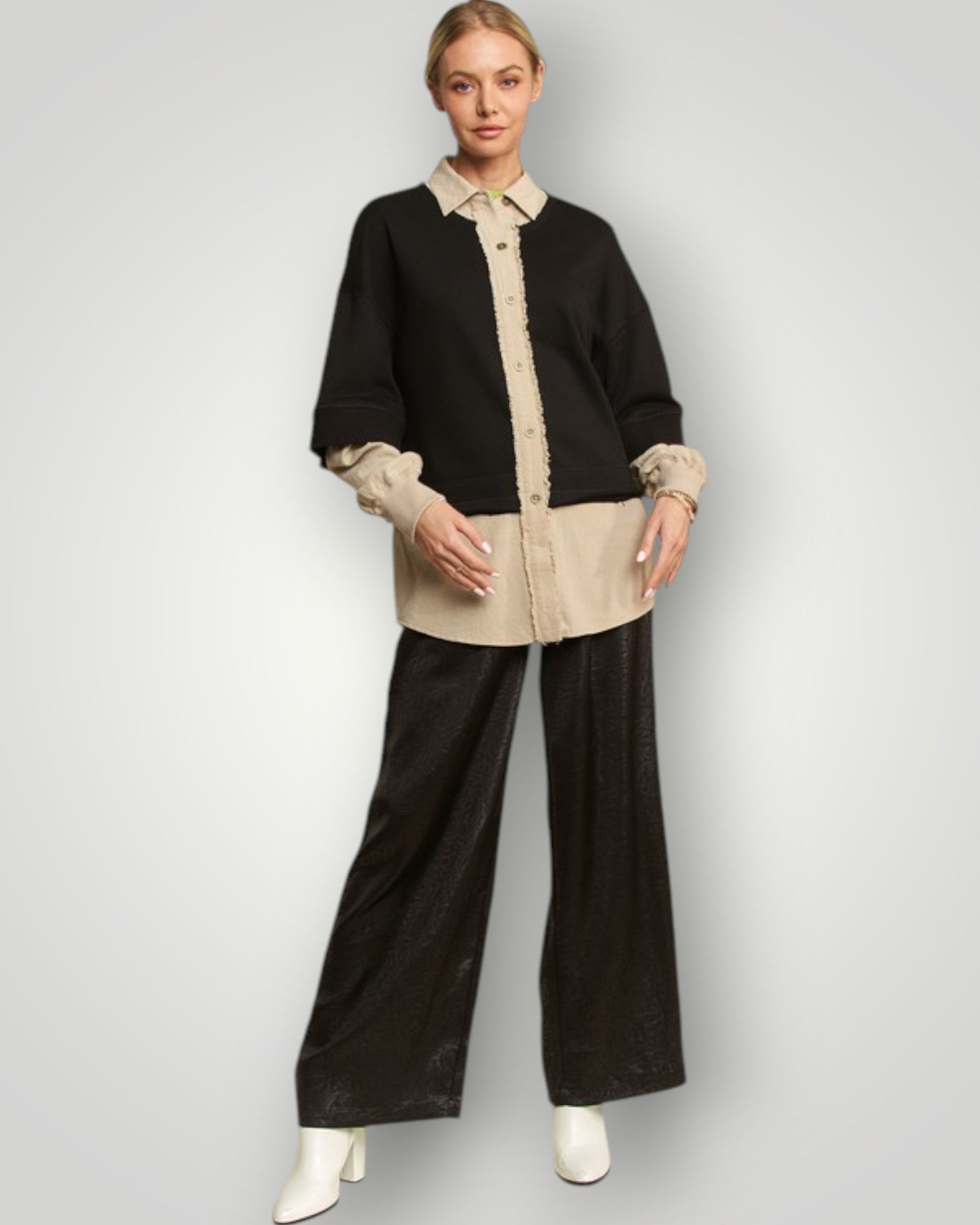 Woman wearing a black and beige outfit with wide-leg pants on a white background