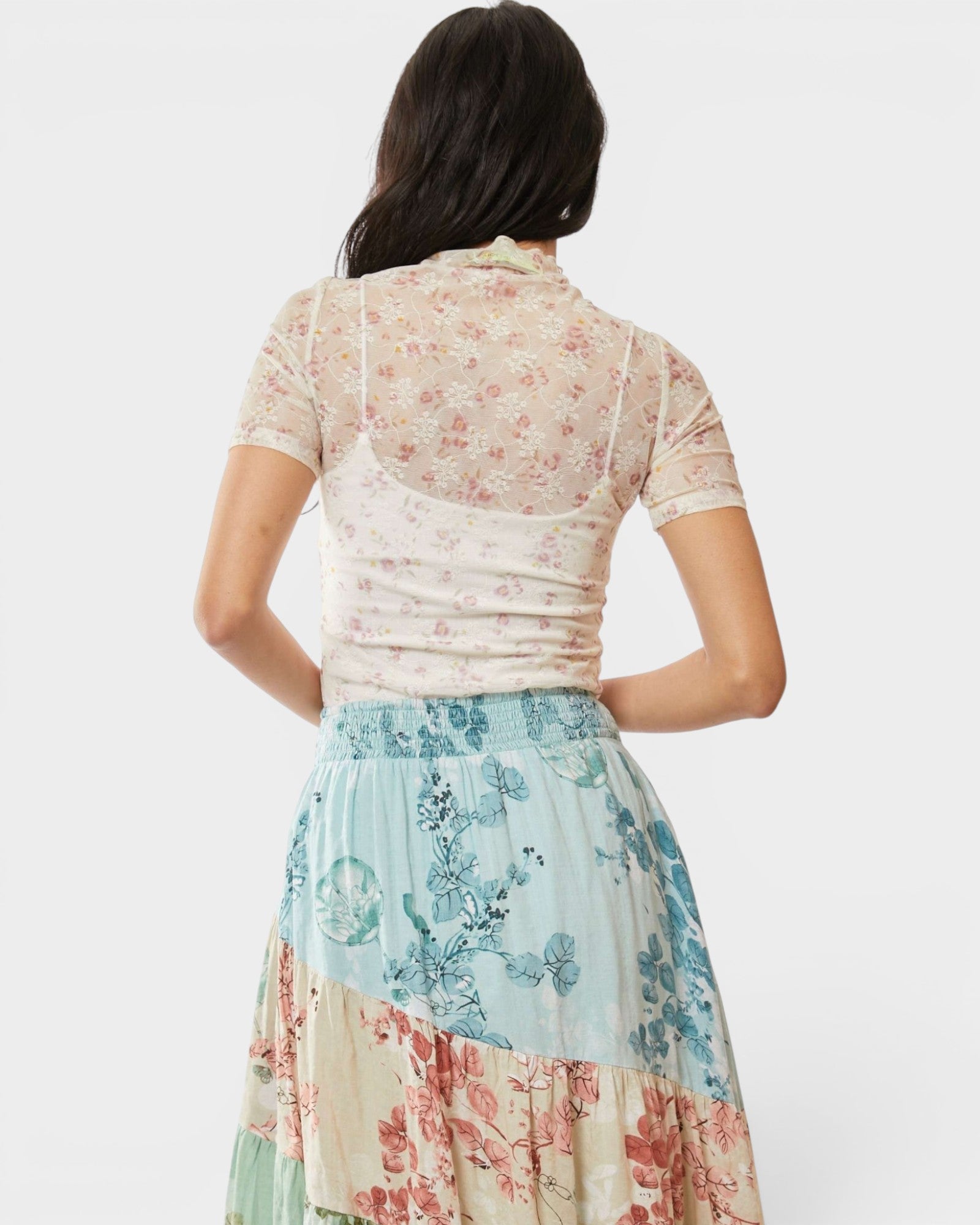 Woman wearing a floral dress with a plain background