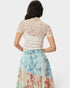 Woman wearing a floral dress with a plain background