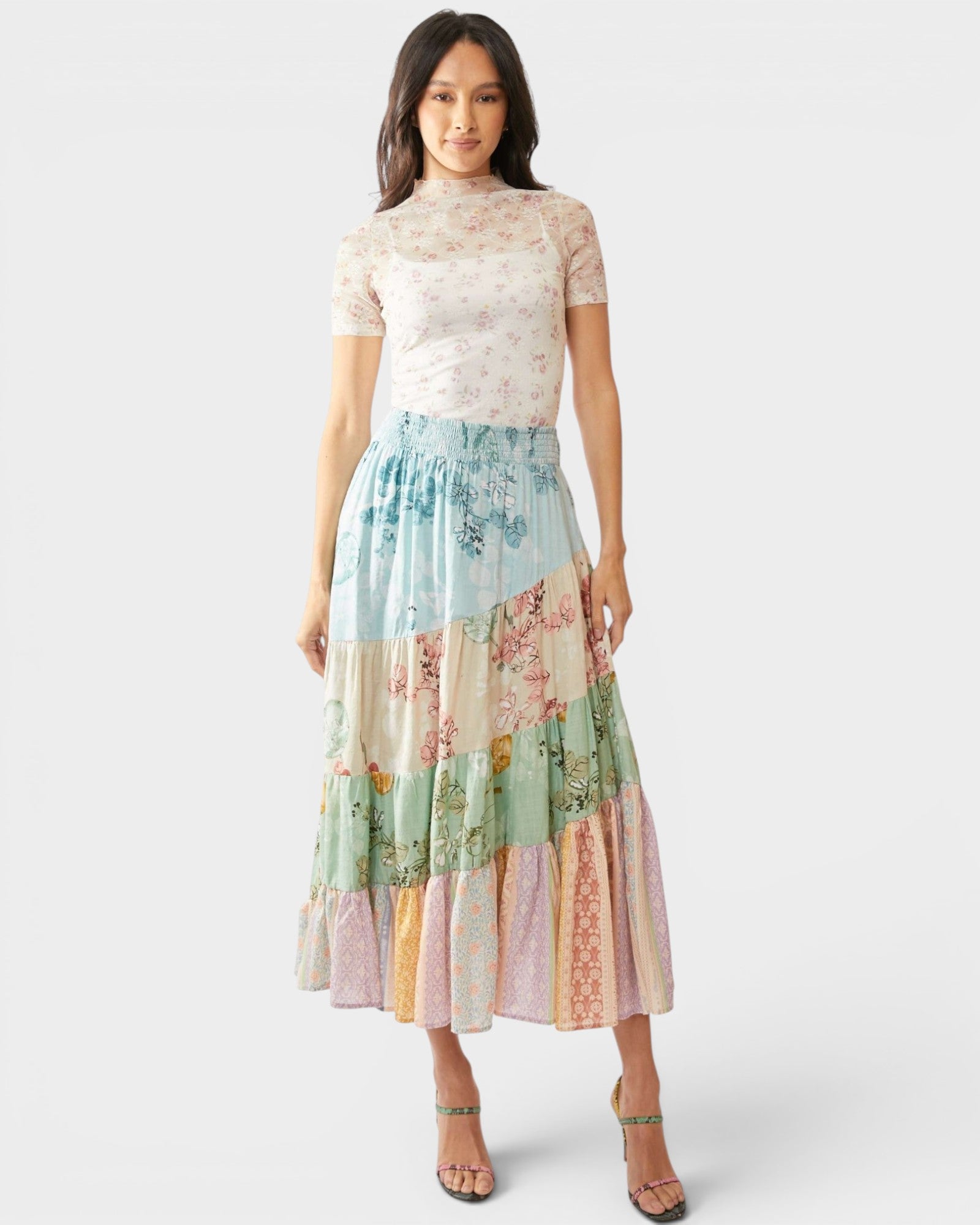 Woman wearing a floral patchwork skirt on a white background