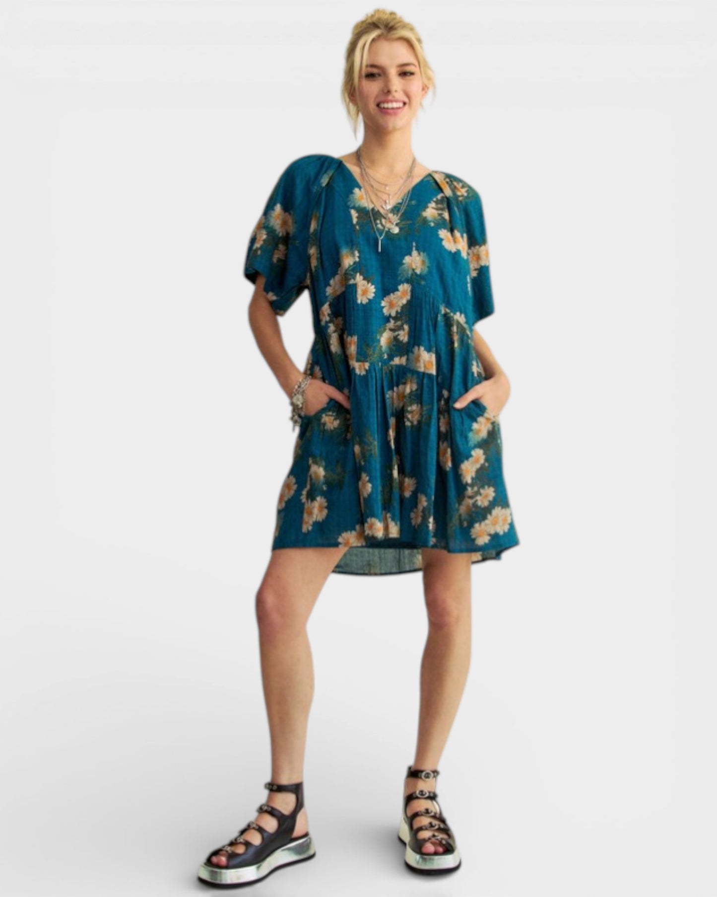 Woman wearing a teal floral dress on a white background