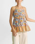 Woman wearing a colorful floral and striped top on a white background