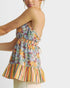 Woman wearing a colorful floral and striped dress on a white background