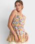 Woman wearing a colorful floral and striped top against a white background