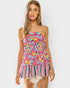 Woman wearing a colorful floral and striped dress on a white background