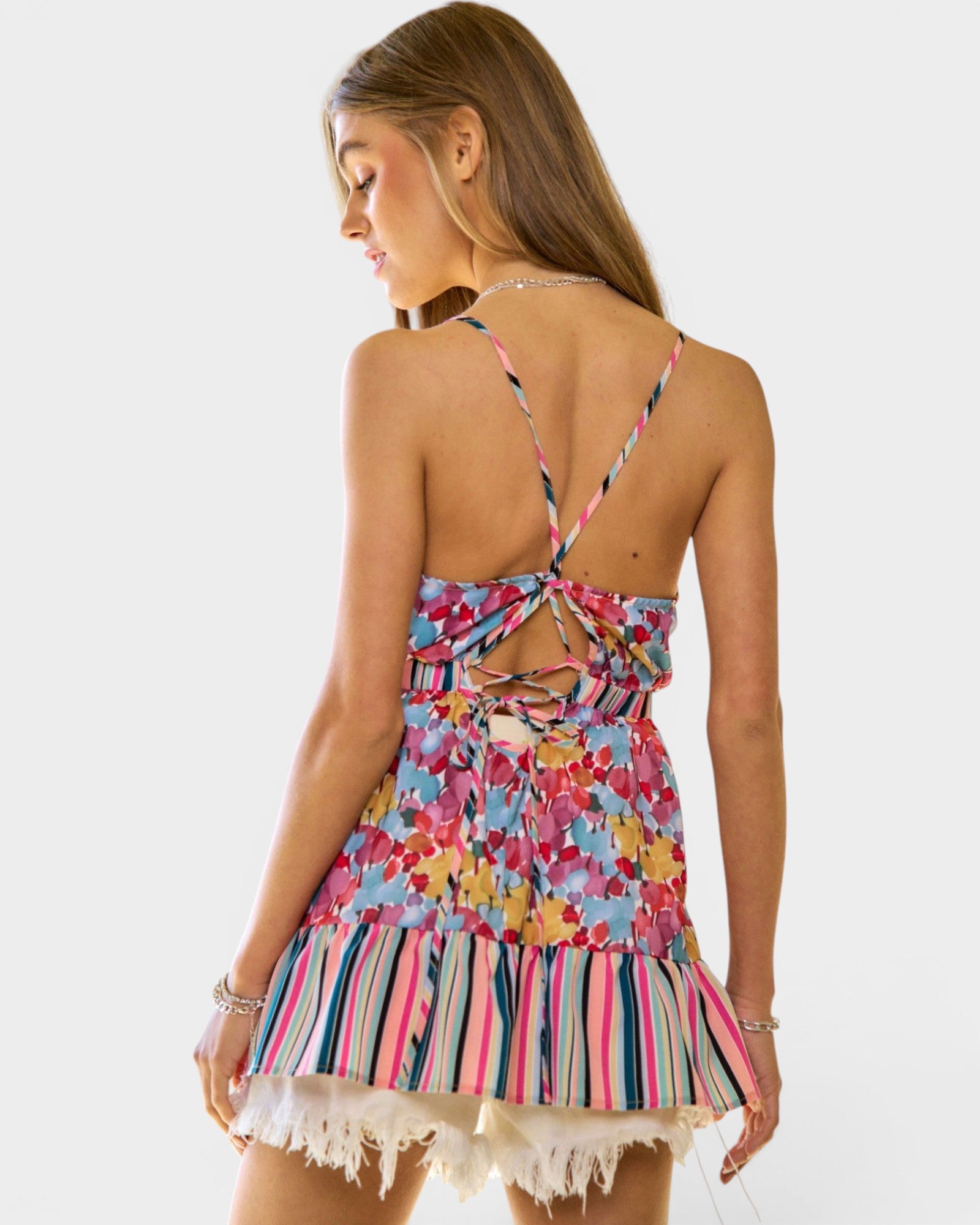 Woman wearing a colorful floral dress with a white background