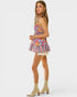Woman wearing a colorful floral dress with striped skirt on a white background