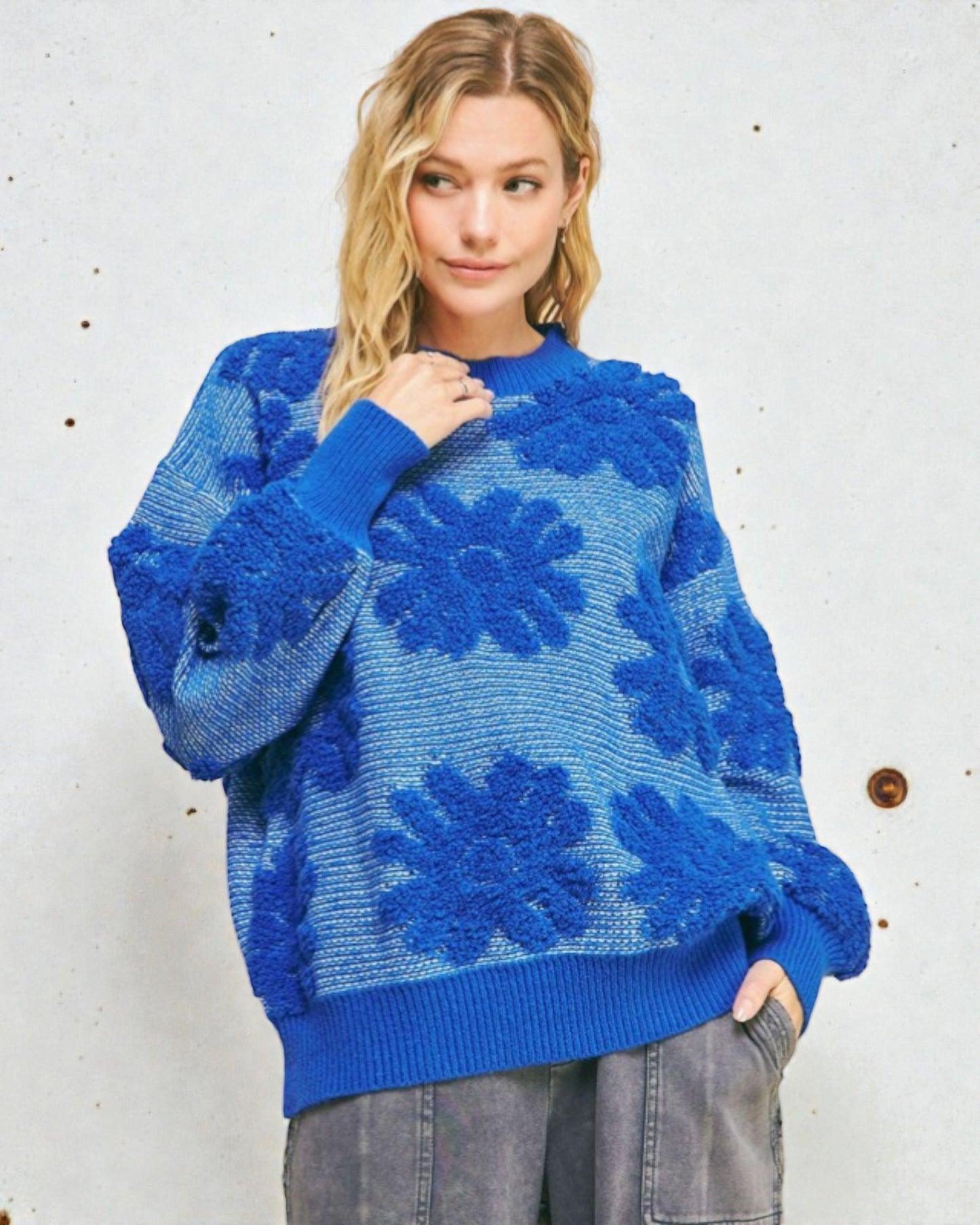 Woman wearing a blue floral-patterned sweater against a white background