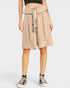 Person wearing a beige skirt with a belt on a white background