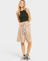 Woman wearing a black sleeveless top and beige high-waisted shorts with a belt on a white background