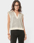 Woman wearing a sleeveless striped top and black pants on a white background