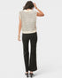 Woman wearing a sleeveless striped top and black pants on a white background