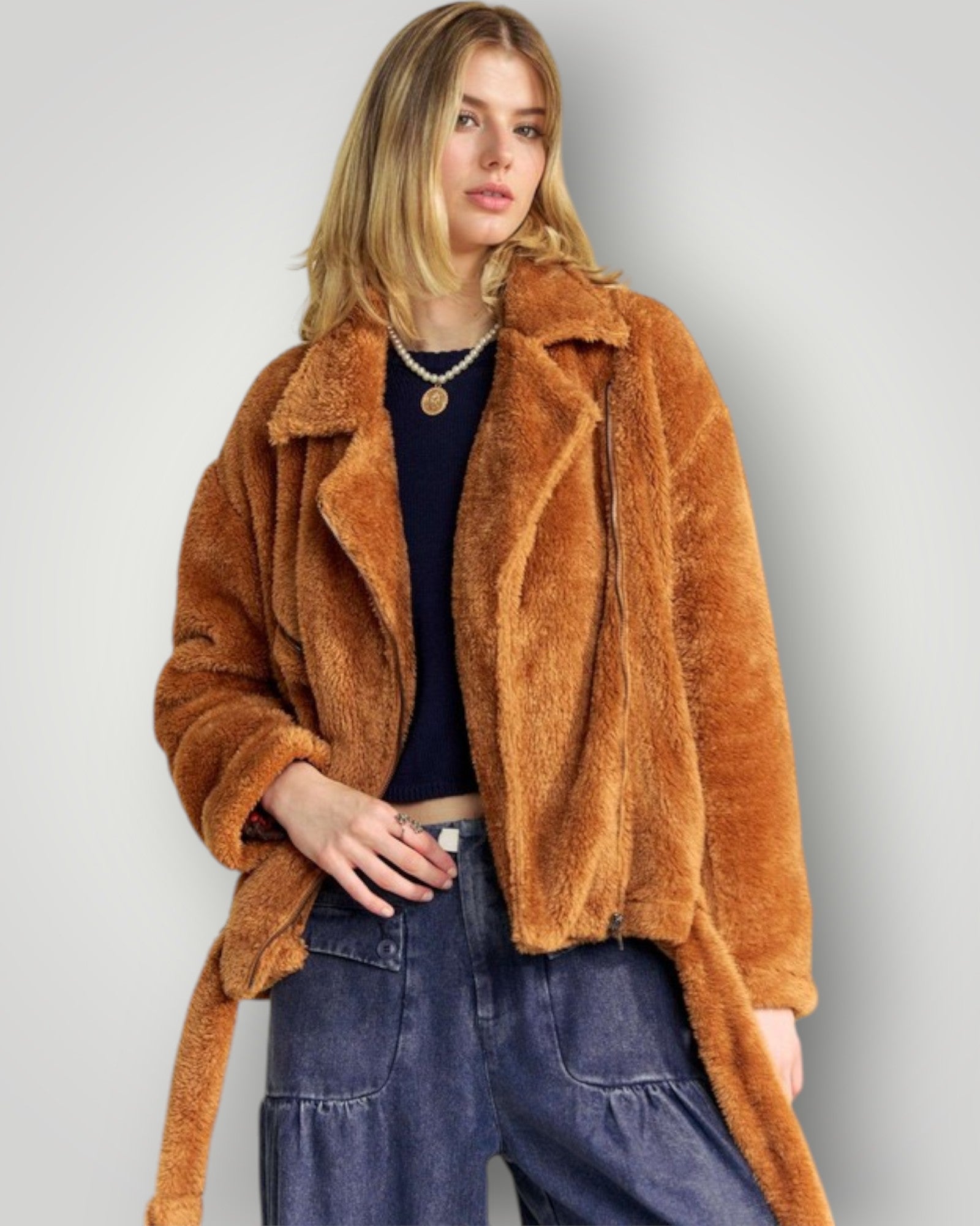 Woman wearing a brown teddy coat against a plain background