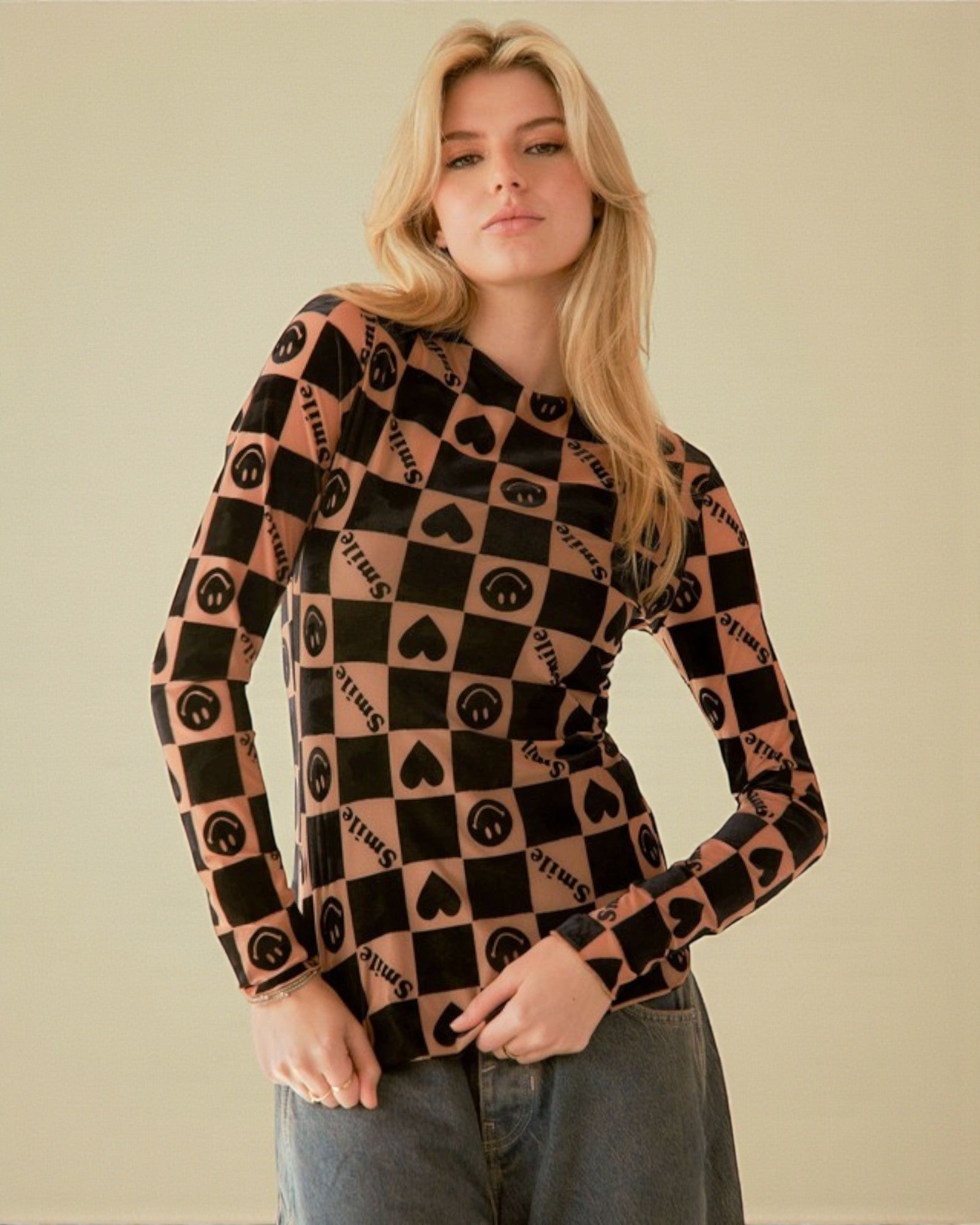 Woman wearing a patterned long-sleeve shirt against a plain background