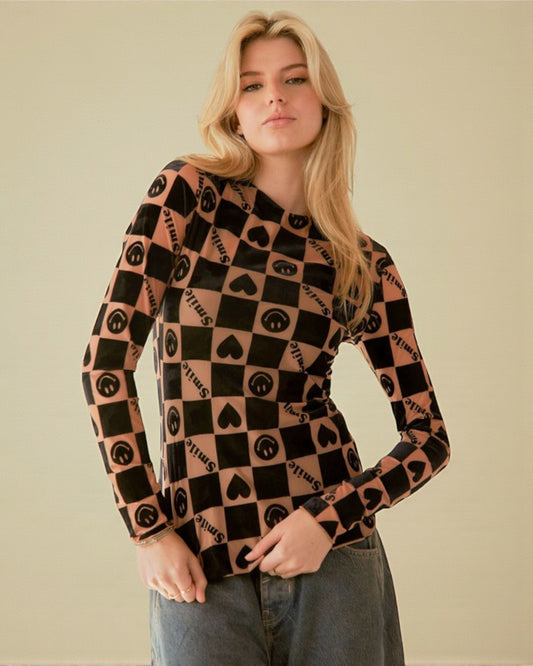 Woman wearing a patterned long-sleeve shirt against a plain background