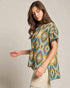 Woman wearing a patterned shirt with a neutral background