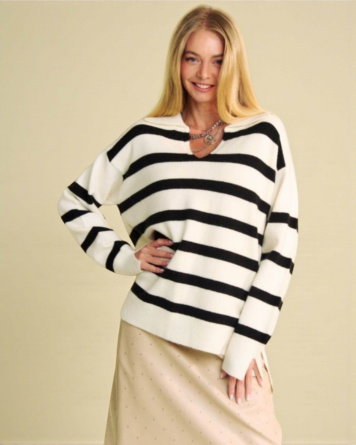 Woman wearing a black and white striped sweater on a beige background
