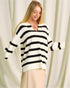Woman wearing a black and white striped sweater against a white curtain background