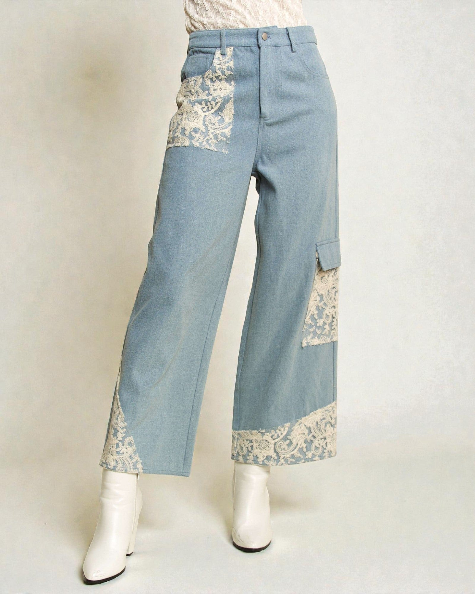 Light blue jeans with lace detailing on a white background