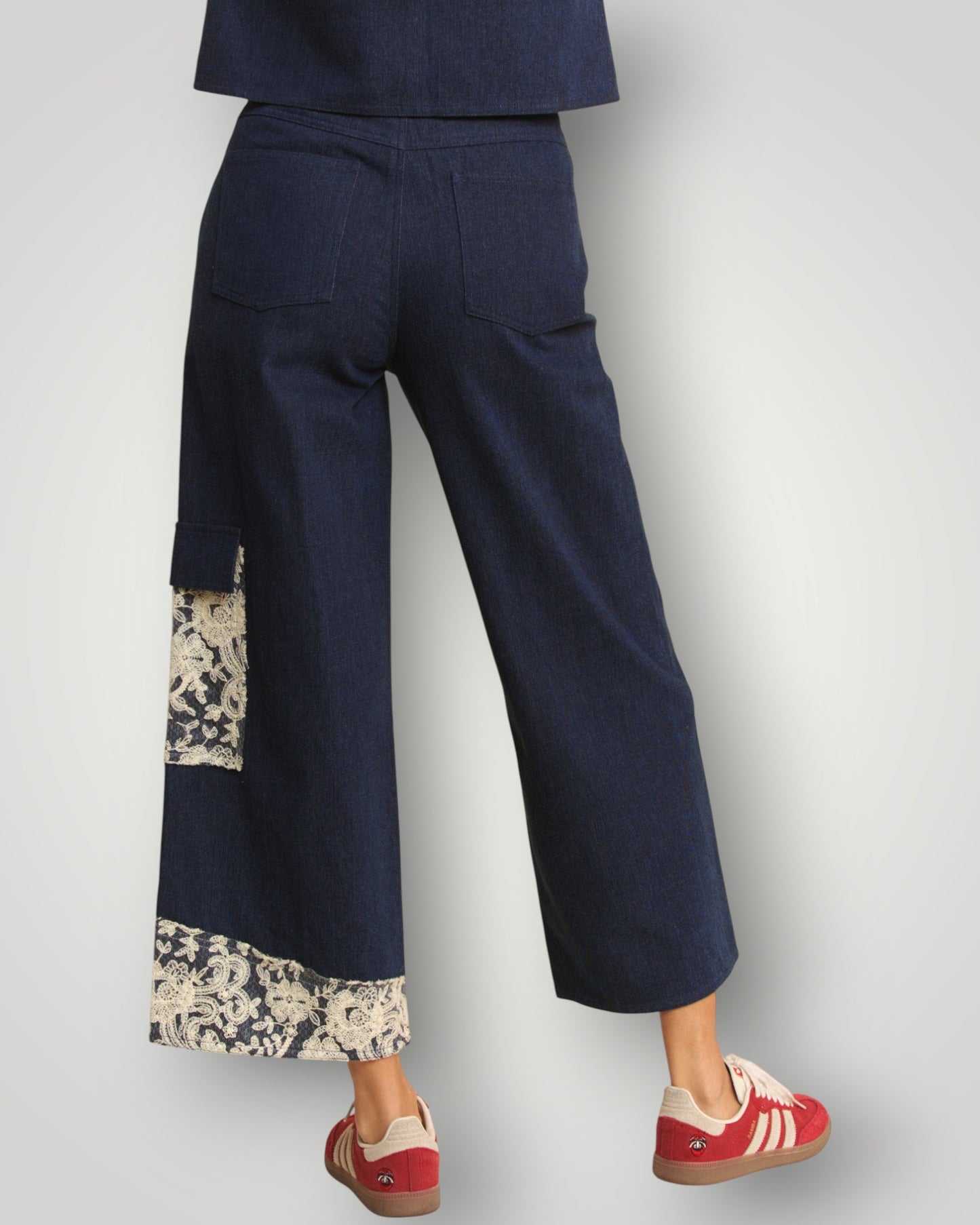 Navy blue pants with floral cuffs and hem on a plain background