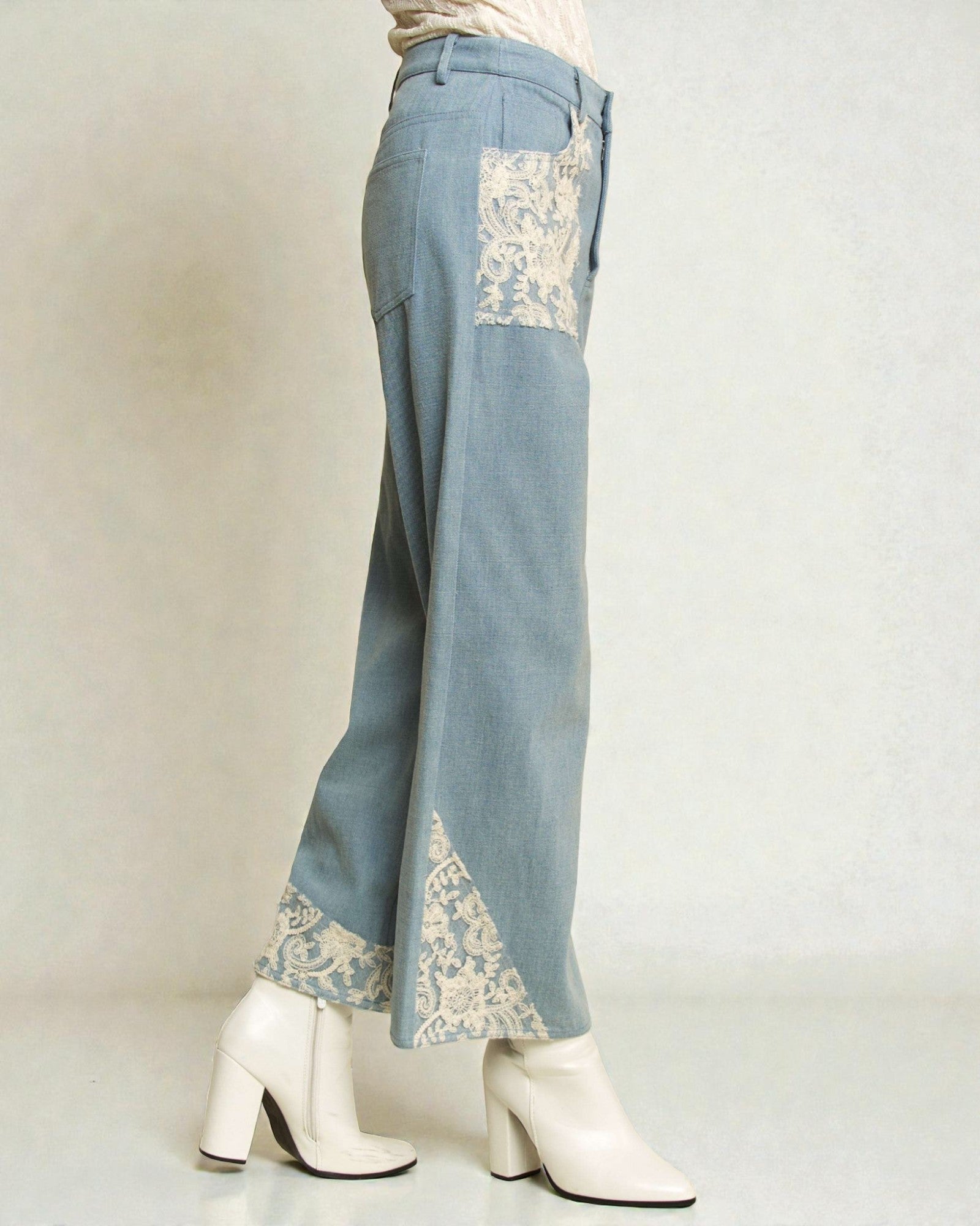 Light blue pants with lace detailing worn by a person on a white background
